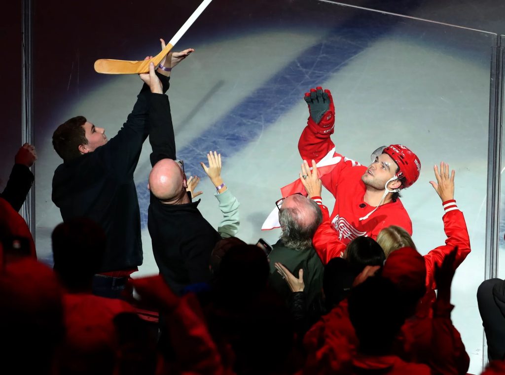 Right wing Alex DeBrincat gives his stick to fans after being named the game's No. 1 star at Little Caesars Arena. (Photo: Kirthmon F. Dozier-USA TODAY Sports)